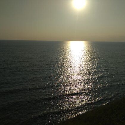 Вид заката с обрыва береговой линии.